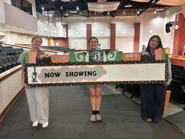 Senior Abby Maxfield, freshman Izzy George, and senior Abby Lima showing off their almost finished sign.
